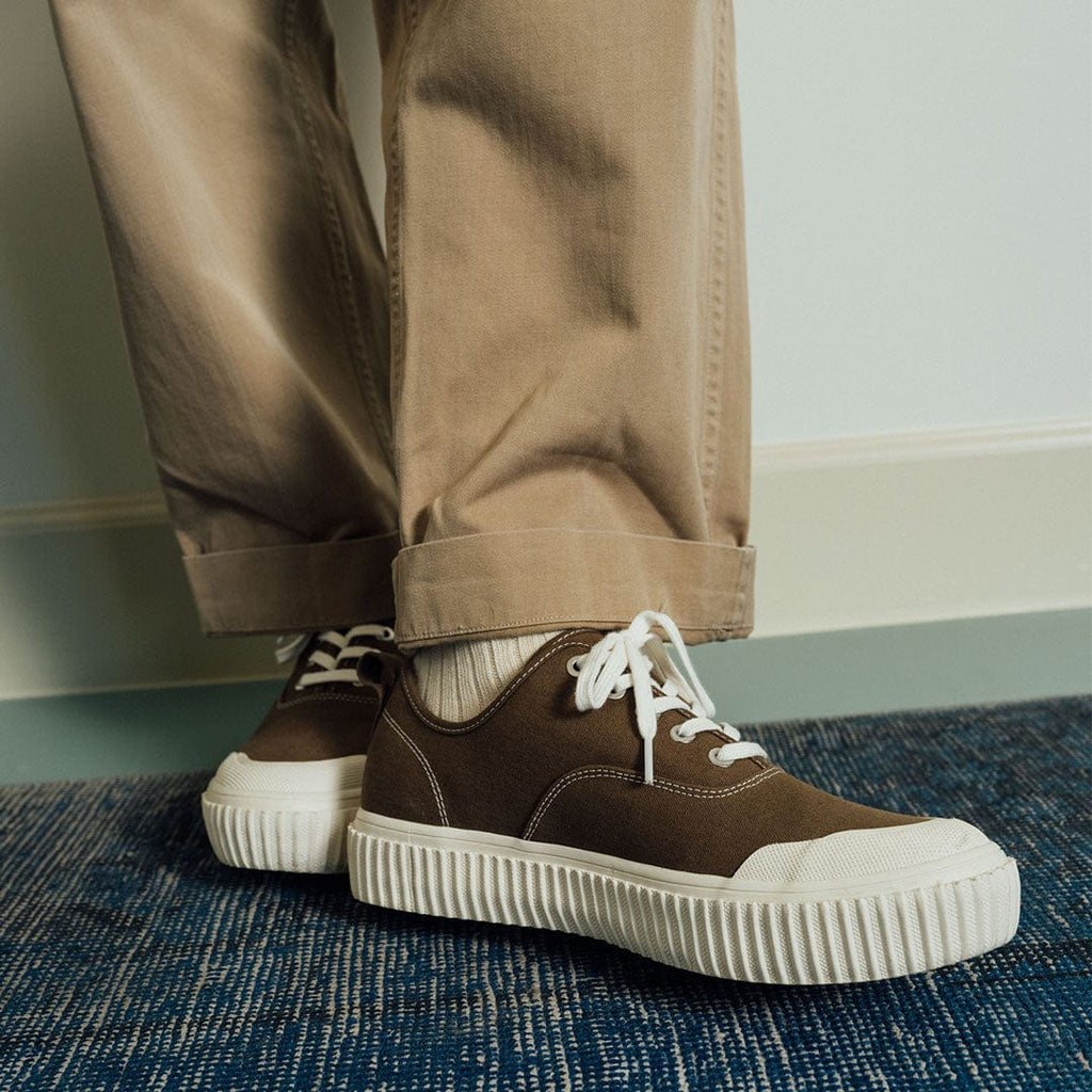 Men's Sato Oxford in Brownstone canvas, worn with khaki pants on a blue rug, front view