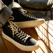 Men's La Brea Lug in Black canvas, worn with cuffed jeans, laces and toe cap, close up
