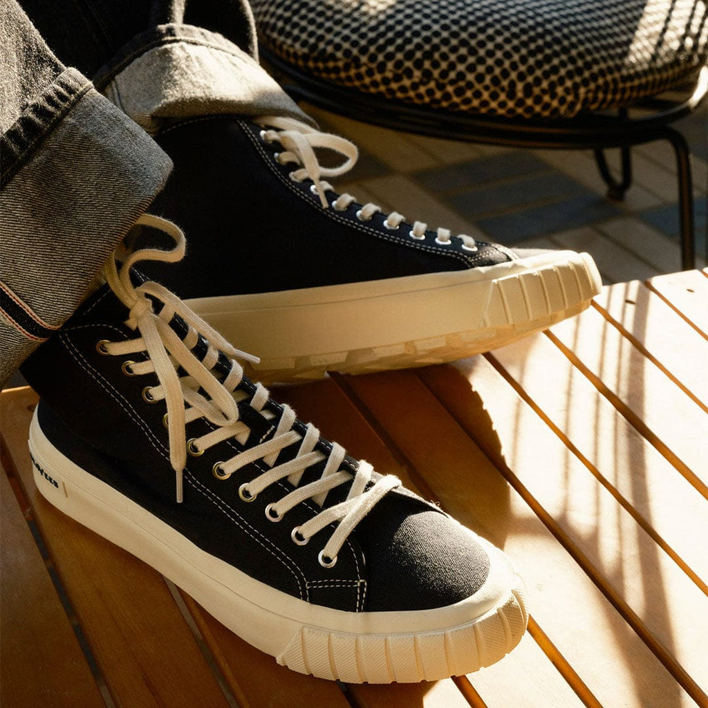 Men's La Brea Lug in Black canvas, worn with cuffed jeans, laces and toe cap, close up