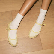 Women's Miramar Espadrille in Butter mesh, worn with white socks on a wood floor, pair from above