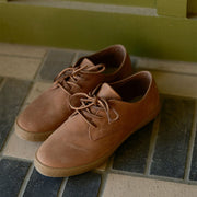 Men's Sun-tans Buck in Timber leather, pair on a tiled floor, angled view