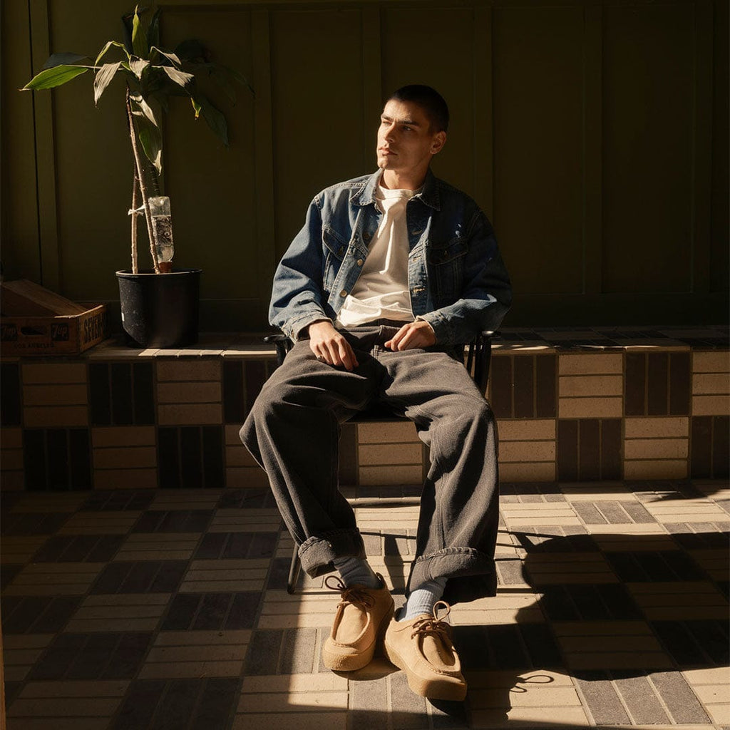 Men's Hayward Loafer in Tan suede, worn by a person seated on a checkered bench in a denim jacket