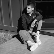 Men's La Brea Lug in White canvas, black and white shot worn by a person seated on steps