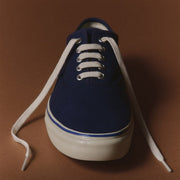 Men's Founders Edition Yacht Shoe in Navy canvas, angled view with white laces on a brown background