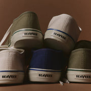 Men's Founders Edition Yacht Shoe in Green canvas, stack of shoes in several colors on a brown background