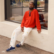Men's Royal Runner sneaker in Blue nylon and suede, worn with white pants by a person seated on a stucco ledge