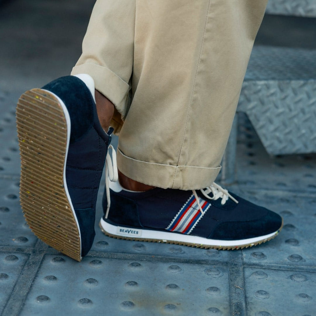 Men's Royal Runner sneaker in Black nylon and suede, side close-up worn with khaki pants on a metal floor
