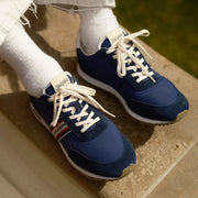 Men's Royal Runner sneaker in Blue nylon and suede, close-up with laces and white socks on a wooden ledge