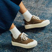 Women's Sato Oxford in Brownstone canvas, worn with white socks on a blue rug, side view