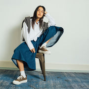 Women's Sato Oxford in Brownstone canvas, worn by a woman seated on a metal stool