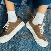 Women's Sato Oxford in Brownstone canvas, pair worn with white socks on a blue rug, front view