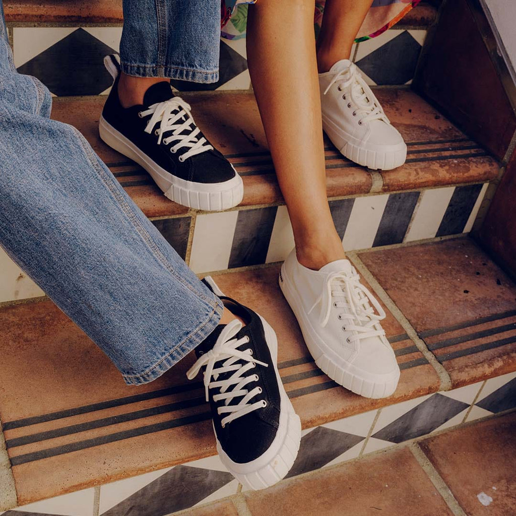 Women's Melrose Lug Platform in Black canvas, close-up worn with jeans on tiled stairs