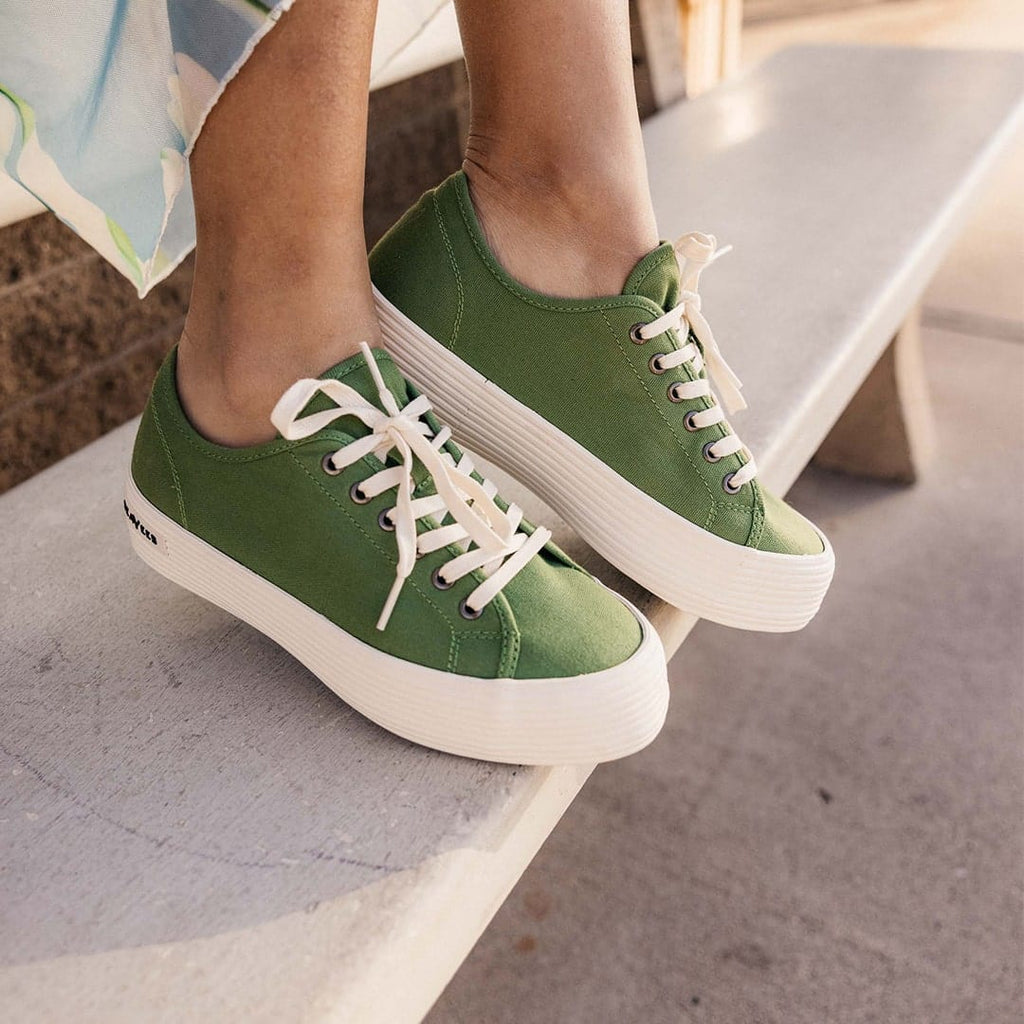 Women's Monterey Sneaker in Cactus canvas, close-up worn on a white bench