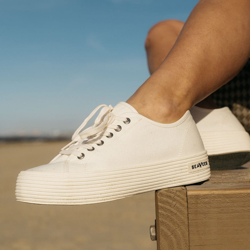 Women's Monterey Sneaker in Bleach canvas, close-up of the platform sole, worn on a wooden crate