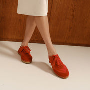 Women's Avenue Espadrille in Strawberry nylon and suede, worn with a cream skirt, standing with crossed legs