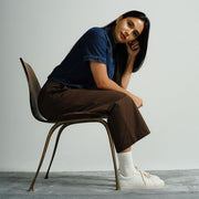 Women's Diamond Cup sneaker in White leather, worn by a woman seated on a chair