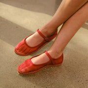 Women's Miramar Espadrille in Forever Red mesh, worn with a bare leg, legs crossed on a tan floor
