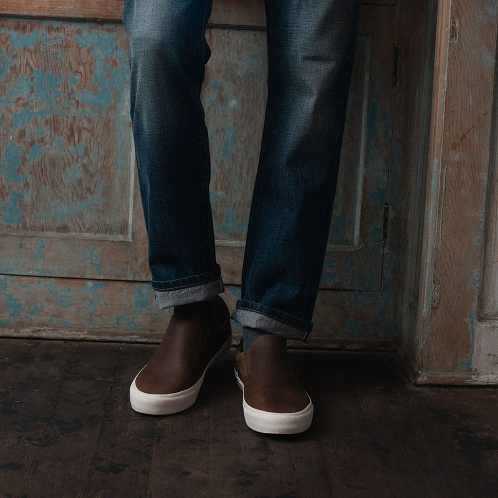 Men's Hawthorne Slip On in Elmwood leather, worn with cuffed jeans on a doorstep