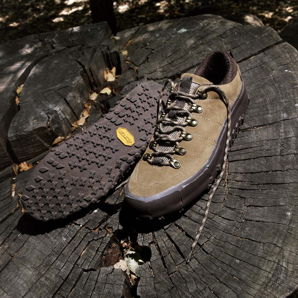 Men's Ridge Urban Hiker hiking sneaker in Desert Palm suede, pair on a tree stump, one showing the Vibram outsole