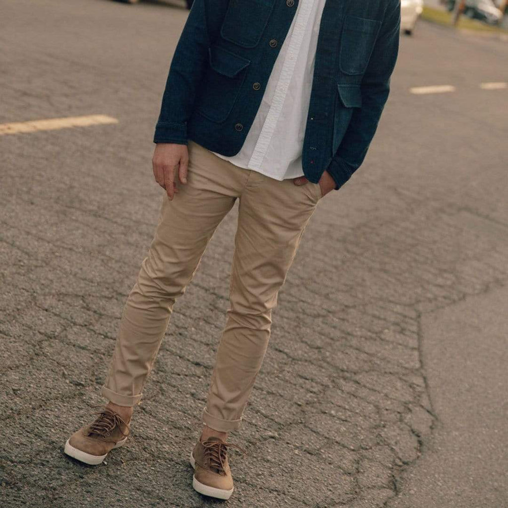 Men's Hermosa Sneaker in Elmwood leather, worn with khaki pants and a navy jacket on pavement