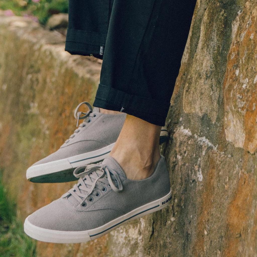 Men's Hermosa Sneaker in Tin Grey canvas, close-up of both shoes with laces, worn on a rocky ledge