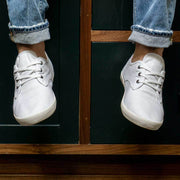 Men's Sixty Six Sneaker in White canvas, front view of both shoes worn with cuffed jeans