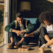 Men's Maslon Desert Boot in Kona leather, worn by two people seated in a doorway