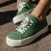 Women's Monterey Sneaker in Cactus canvas, worn on dark pavement with bare ankles, close up