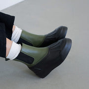 Women's Chalet Chelsea Boot in Utility Olive leather, worn with white socks and black pants, side view